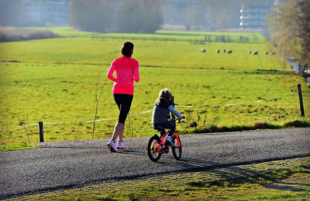 žena běží a dítě jede na kole